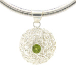 Load image into Gallery viewer, Silver necklace with a round pendant featuring a green gemstone on a white background
